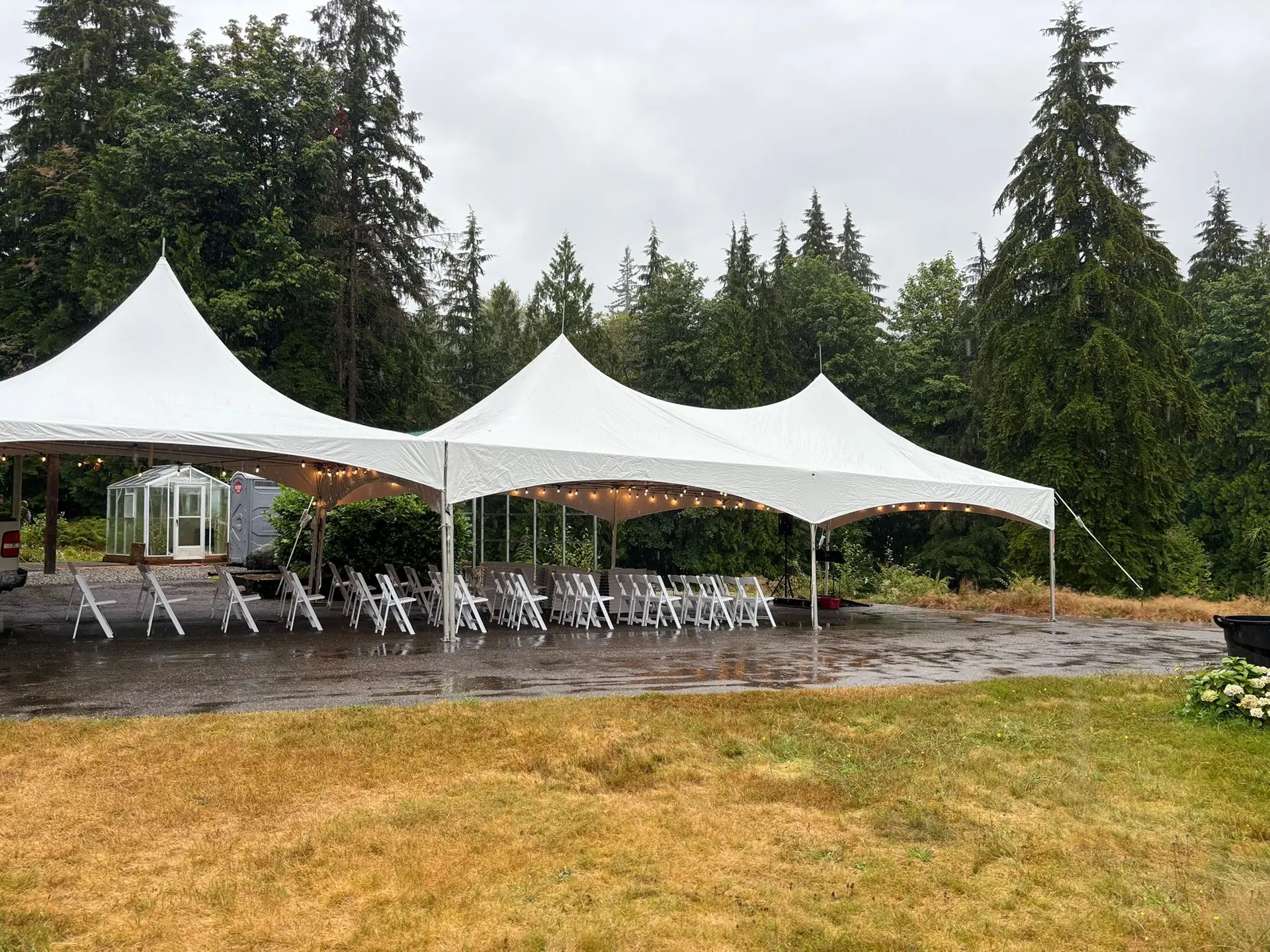 Three connected white high-peak tents set up for an outdoor event