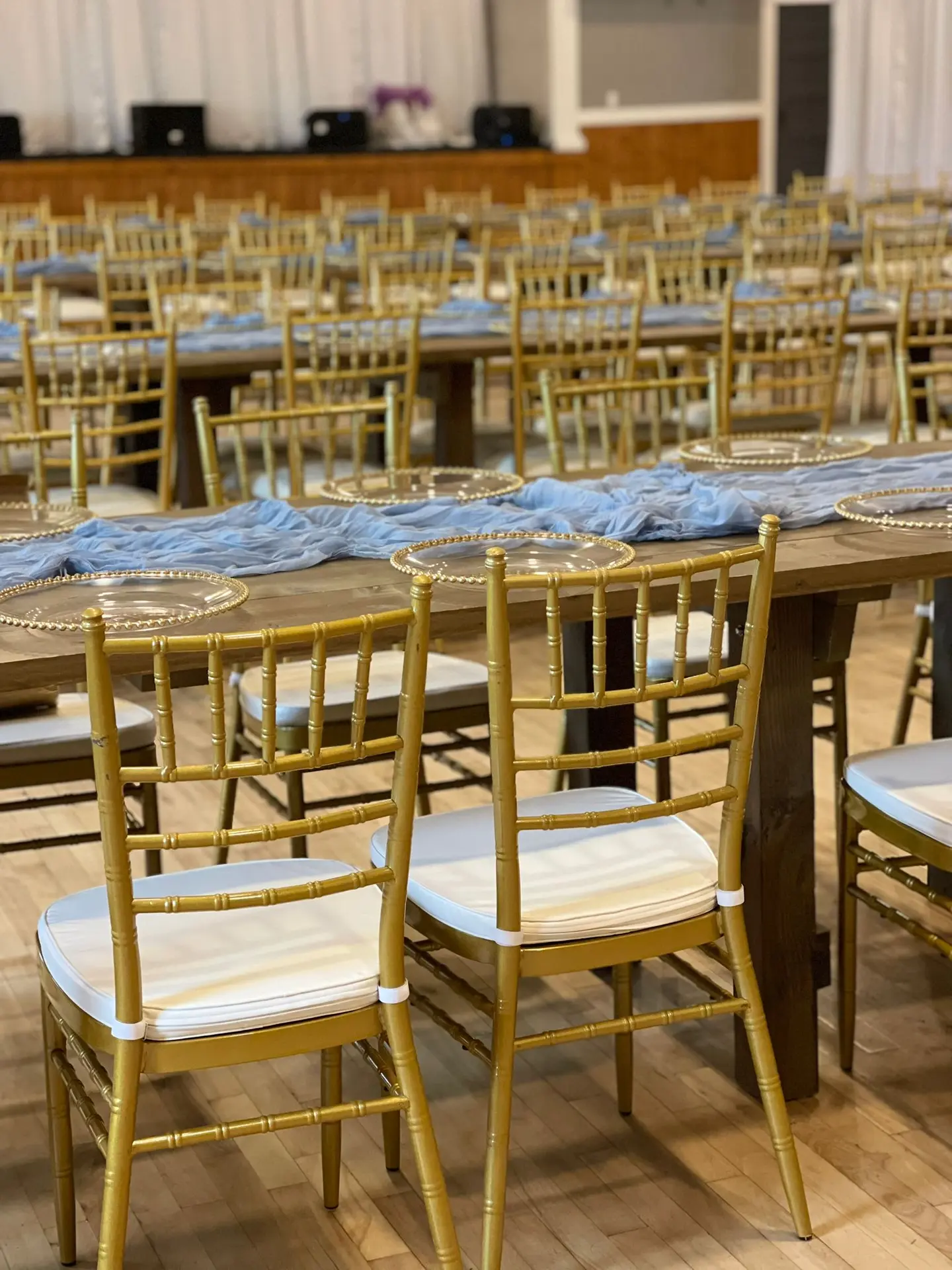Close view of gold chiavari chairs and a reception table setting